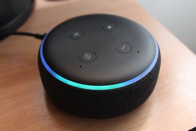 Amazon Alexa device sitting on a corner of a desk.