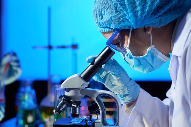 Woman looking into an eyepiece of a microscope.