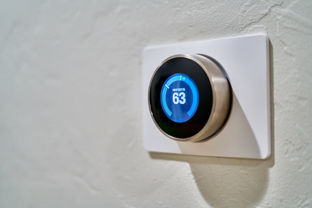 Smart Thermostat on a wall, the temperature is set to 63 degrees.